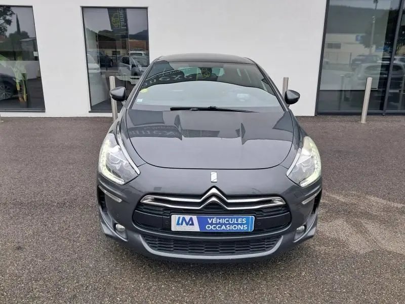 Vue frontale d'une Citroën DS5 gris foncé métal 2014 avec calandre distinctive et phares allumés.