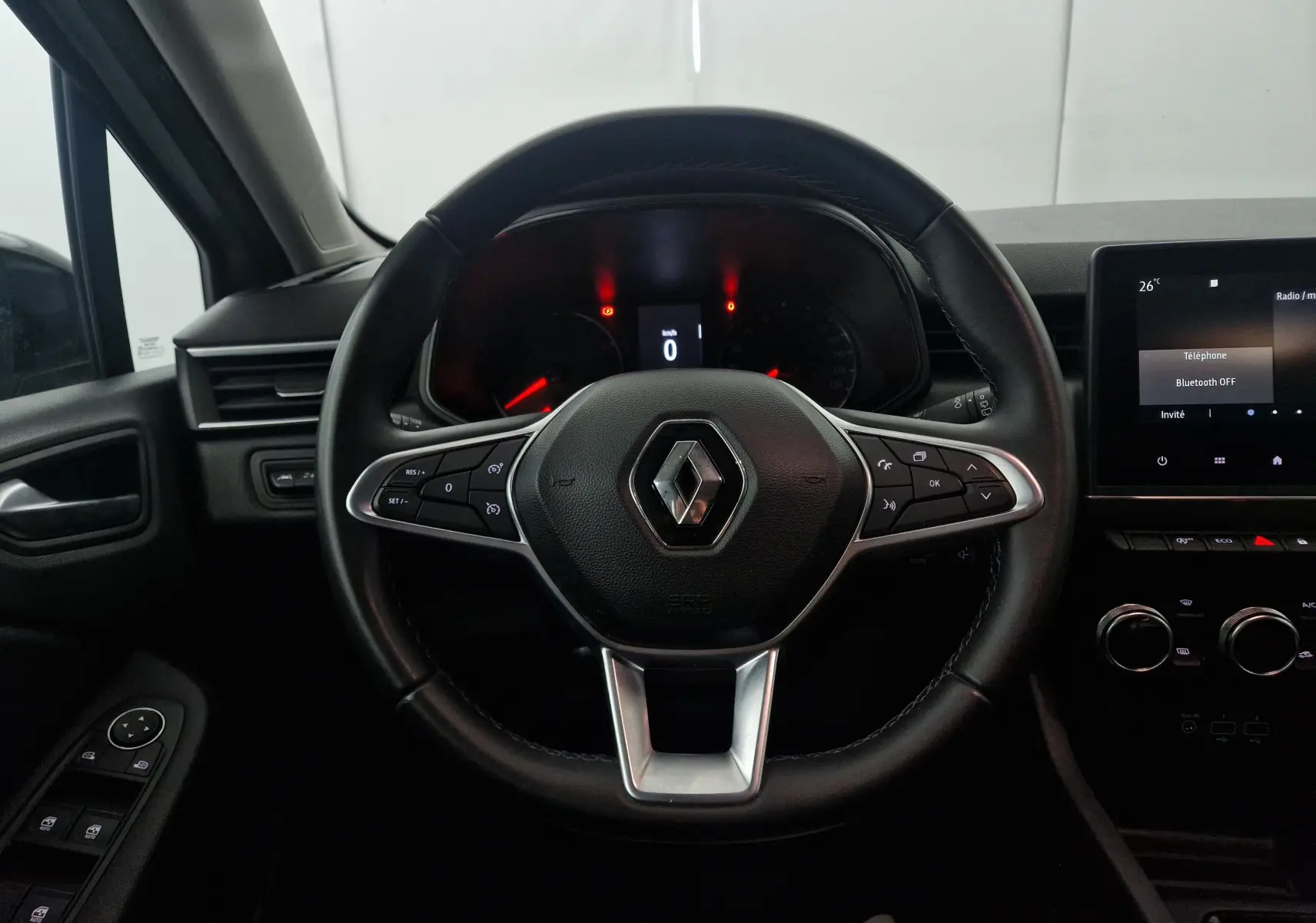 Vue intérieure centrée sur le volant noir de la Renault Clio V 1.0 TCE 90 Zen avec tableau de bord et écran tactile.