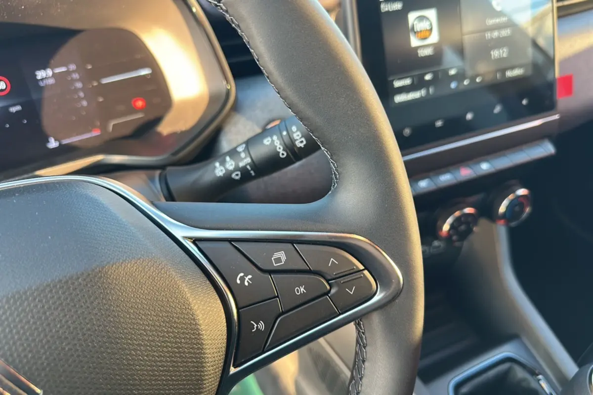 Gros plan sur le volant et tableau de bord de la Renault Clio DCI 100 Evolution Camera 2025 en gris rafale.