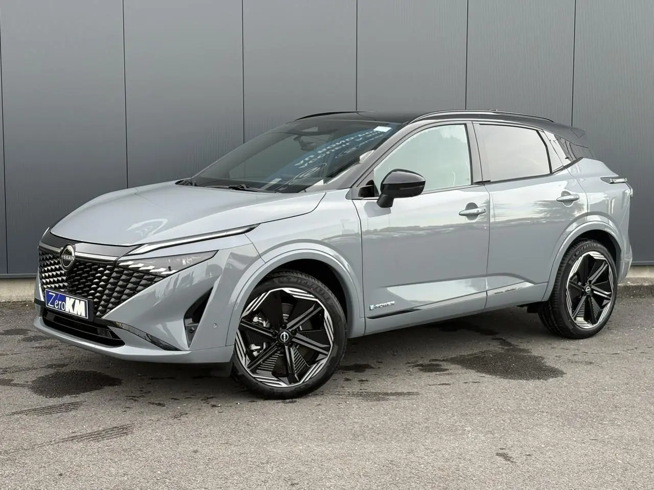 Nissan Qashqai gris Ceramic en 3/4 avant droit avec toit noir panoramique et jantes alliage 20 pouces noires.