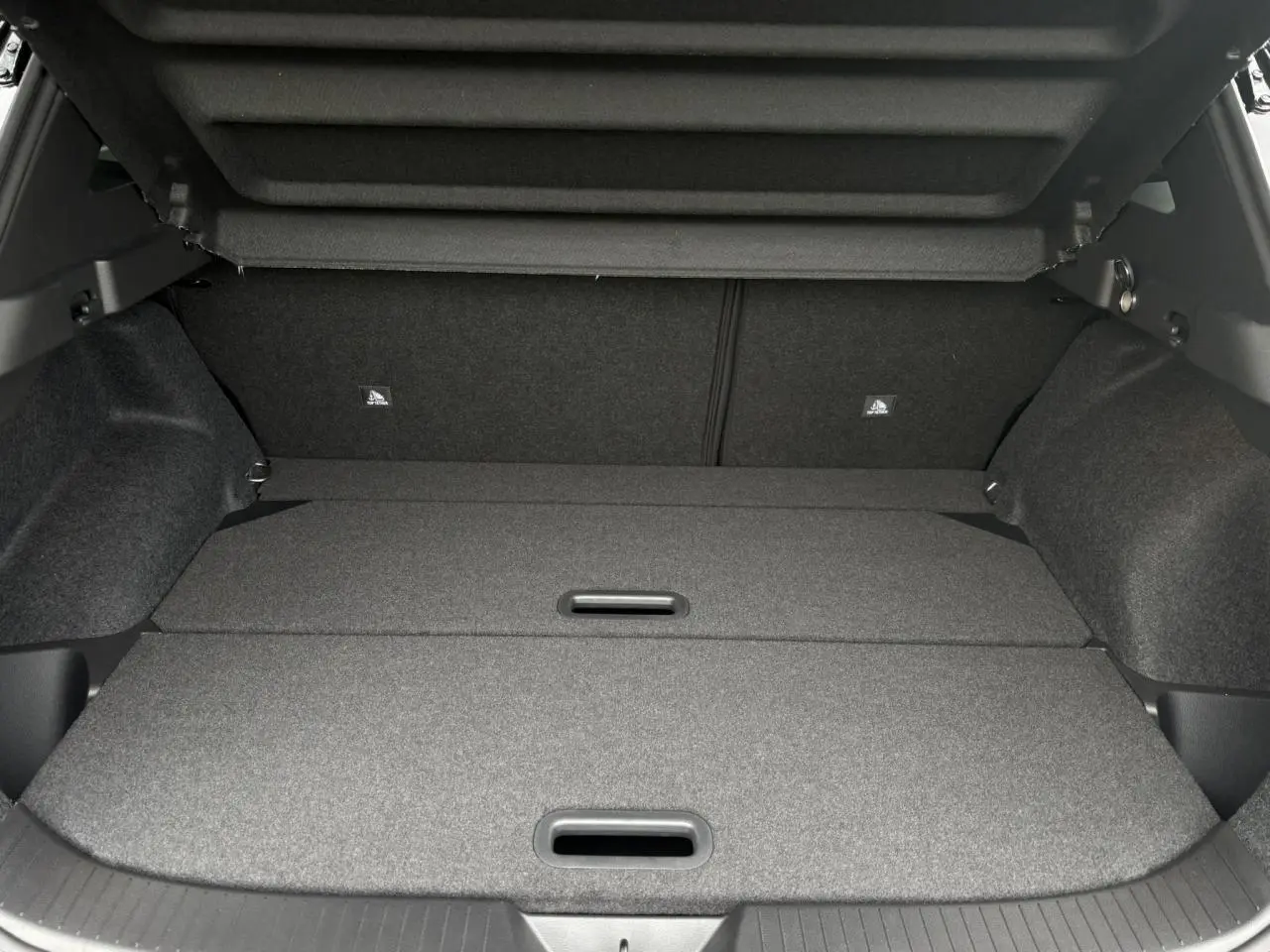 Coffre modulable du Nissan Qashqai gris Ceramic vu de l'arrière avec plancher plat et cache-bagages relevé.