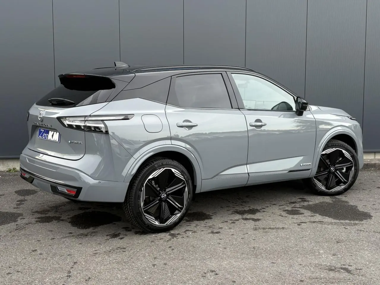 Vue 3/4 arrière droite du Nissan Qashqai 2025 gris Ceramic avec toit noir et jantes alliage noires.