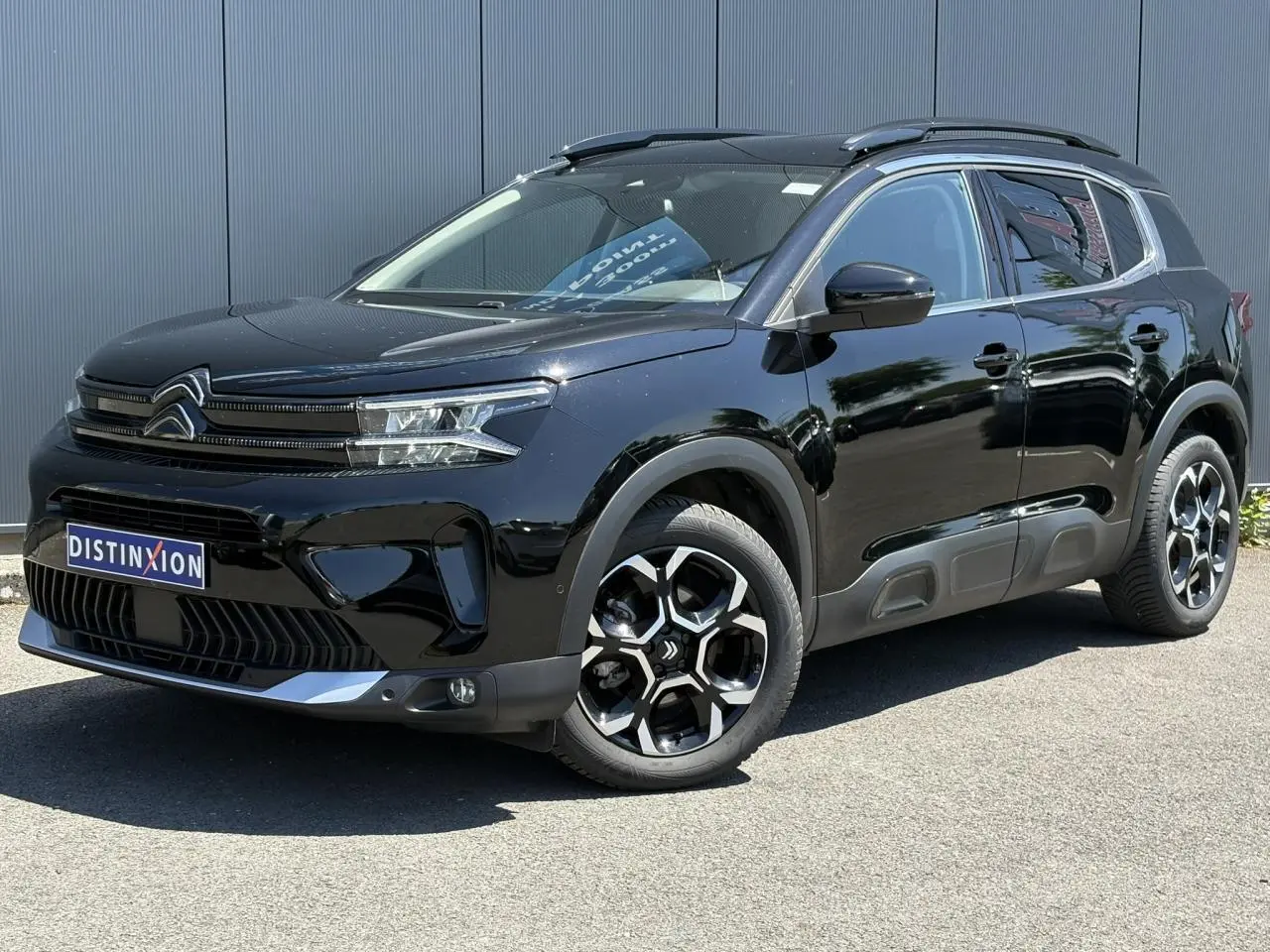 Citroën C5 Aircross Hybrid noir Perla vue 3/4 avant droit, jantes alliage bi-ton et barres de toit noires.