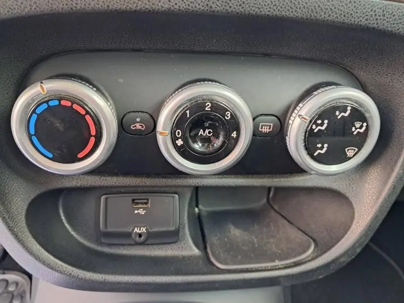 Gros plan sur les commandes de climatisation et connectique USB/AUX d'une Fiat 500L beige de 2014, version Tekking.