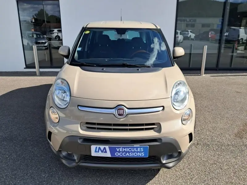 Vue frontale d'une Fiat 500L beige 2014 avec logo FIAT centré et plaque "Véhicules Occasions" visible.