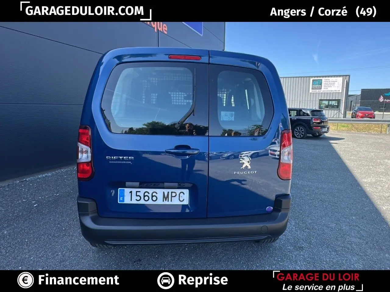 Vue arrière d'un Peugeot Rifter bleu 2024 avec portes battantes et logo visible sur parking extérieur.