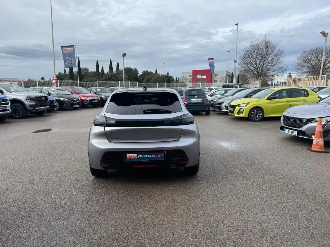 Vue arrière d'une Peugeot 208 Hybrid 110 gris métallisé, avec feux arrière noirs et jantes alliage 17 pouces.