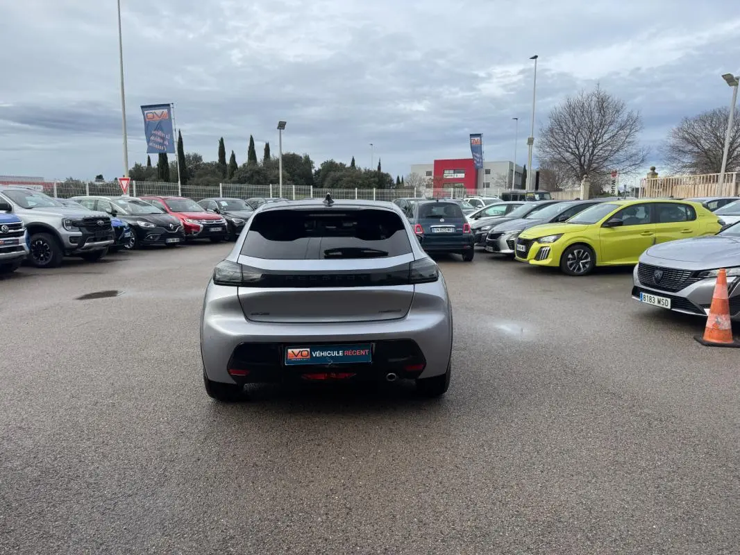 Vue arrière d'une Peugeot 208 Hybrid 110 gris métallisé, avec feux arrière noirs et jantes alliage 17 pouces.