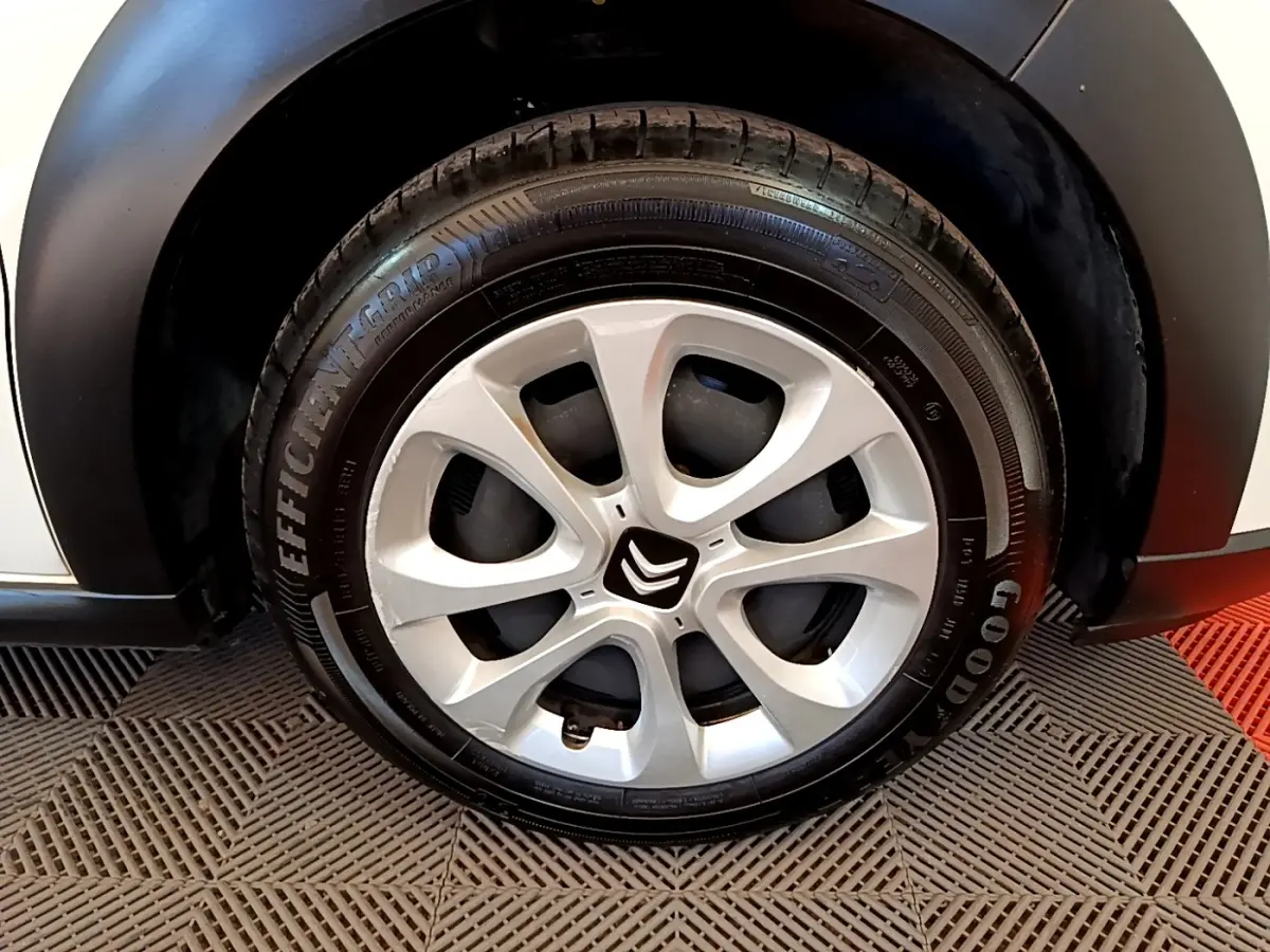 Gros plan sur la roue avant droite blanche d'une Citroën C3 2022 avec jante alliage et logo Citroën central.