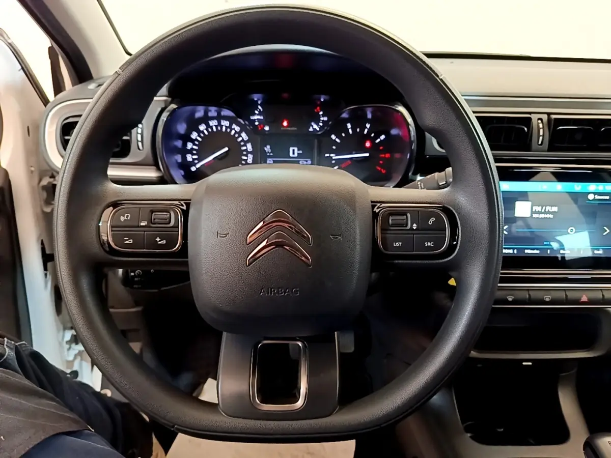 Vue intérieure centrée sur le volant multifonctions noir de la Citroën C3 2022 avec tableau de bord et écran tactile visibles.