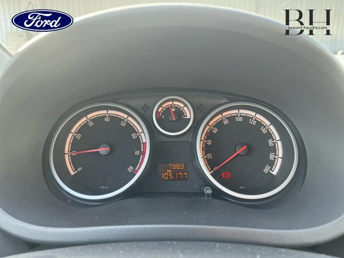 Vue rapprochée du tableau de bord de l'Opel Corsa noir, affichant le compteur de vitesse et le compte-tours.