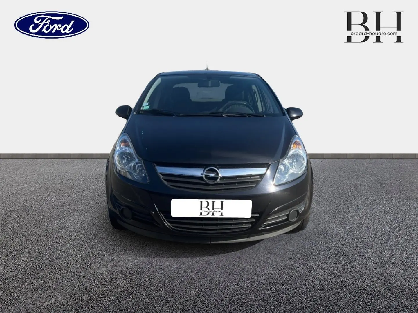 Vue de face d'une Opel Corsa noire de 2010, mettant en valeur sa calandre chromée et ses phares arrondis.