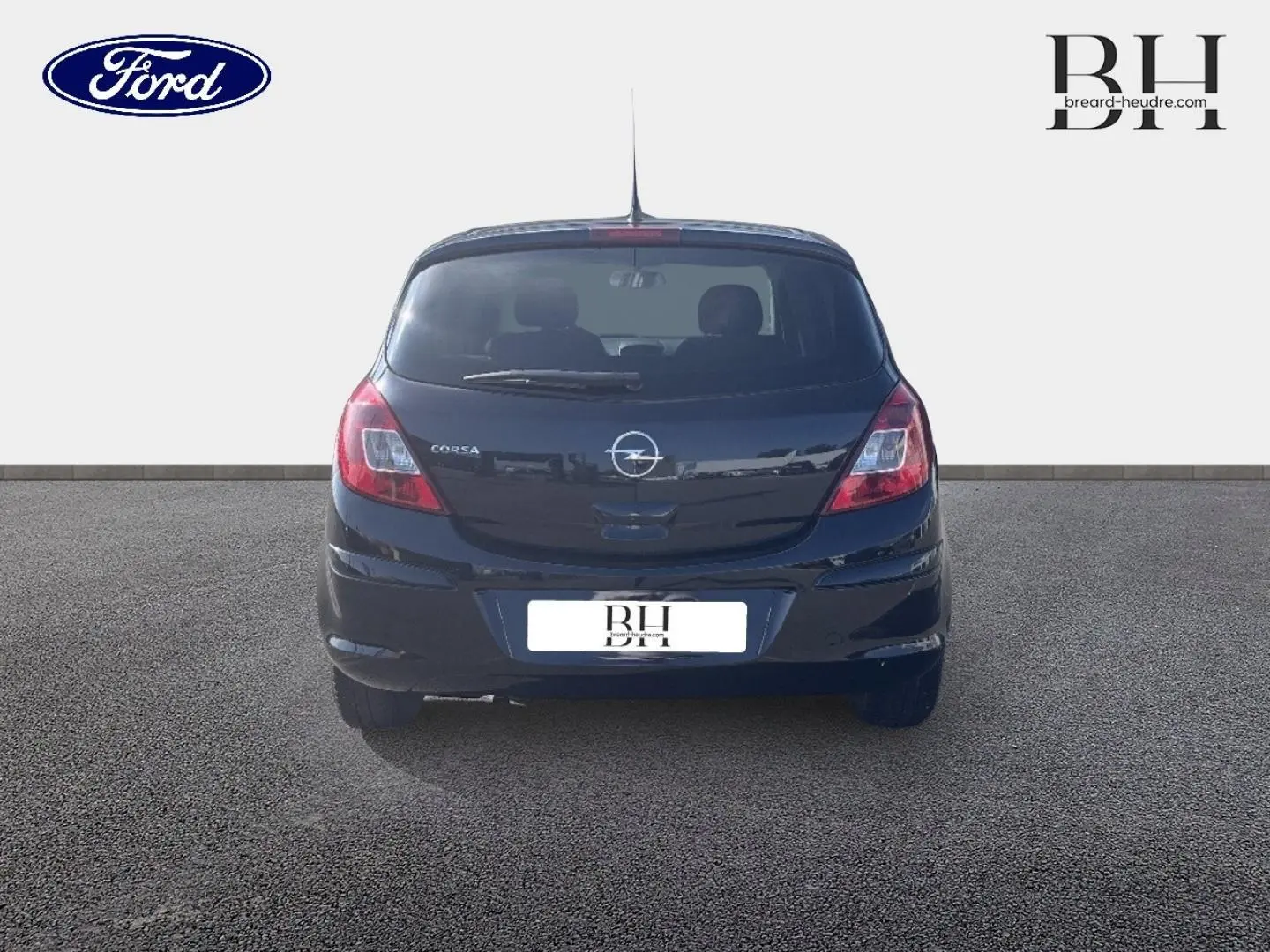 Vue arrière d'une Opel Corsa noire de 2010, compacte avec feux arrière rouges et lunette arrière avec essuie-glace.