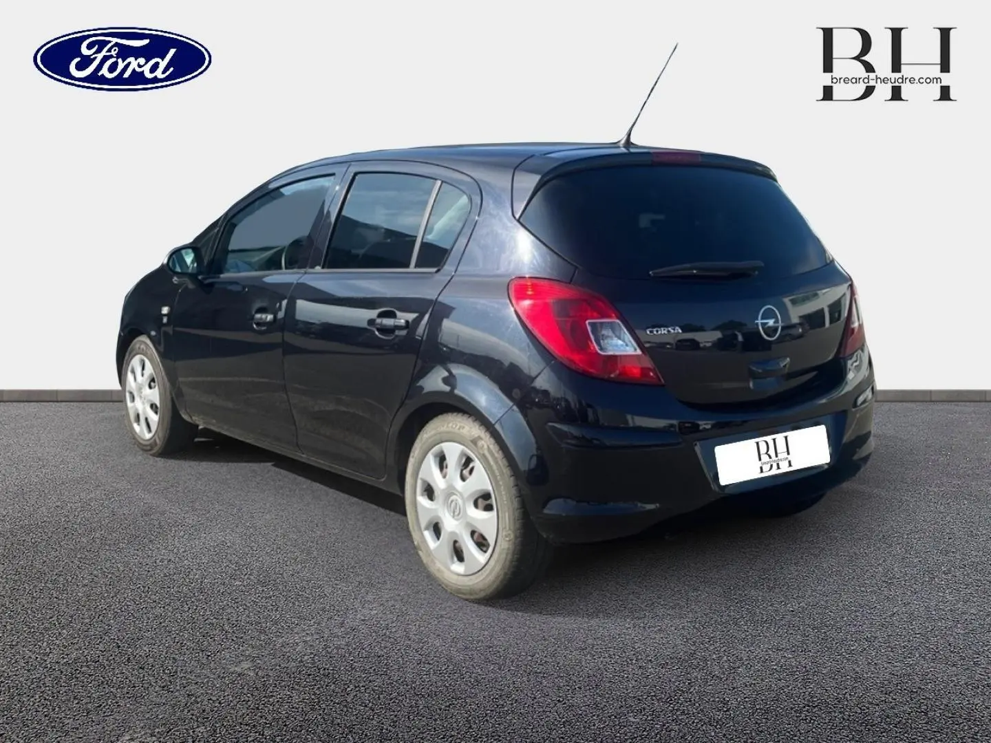 Vue 3/4 arrière droite d'une Opel Corsa noire de 2010, compacte avec feux arrière rouges et jantes argentées.