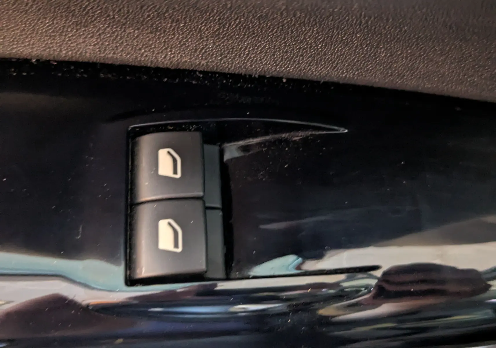 Gros plan sur les boutons de commande des vitres électriques côté conducteur d'une Citroën C4 Cactus 2019.