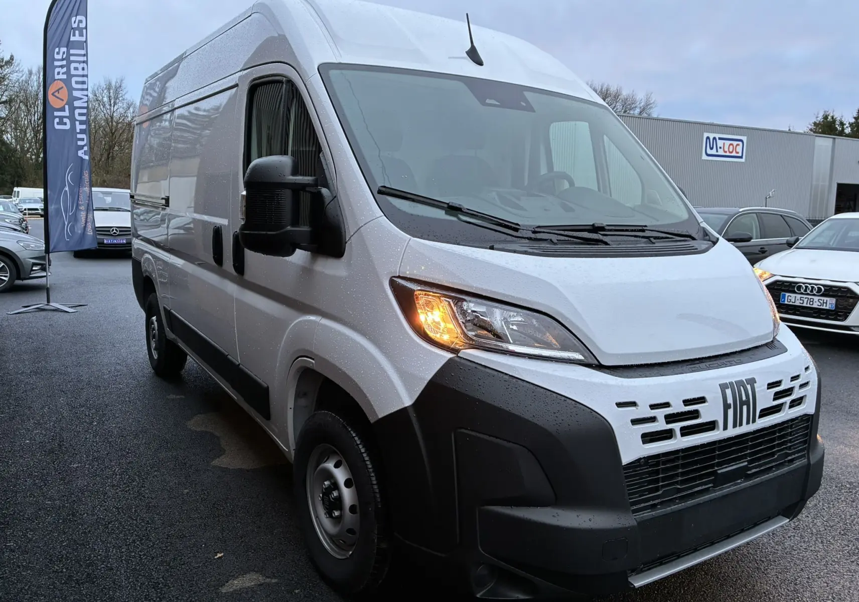 FIAT Ducato Fourgon blanc vu en 3/4 avant droit, phare avant allumé et calandre noire distinctive.