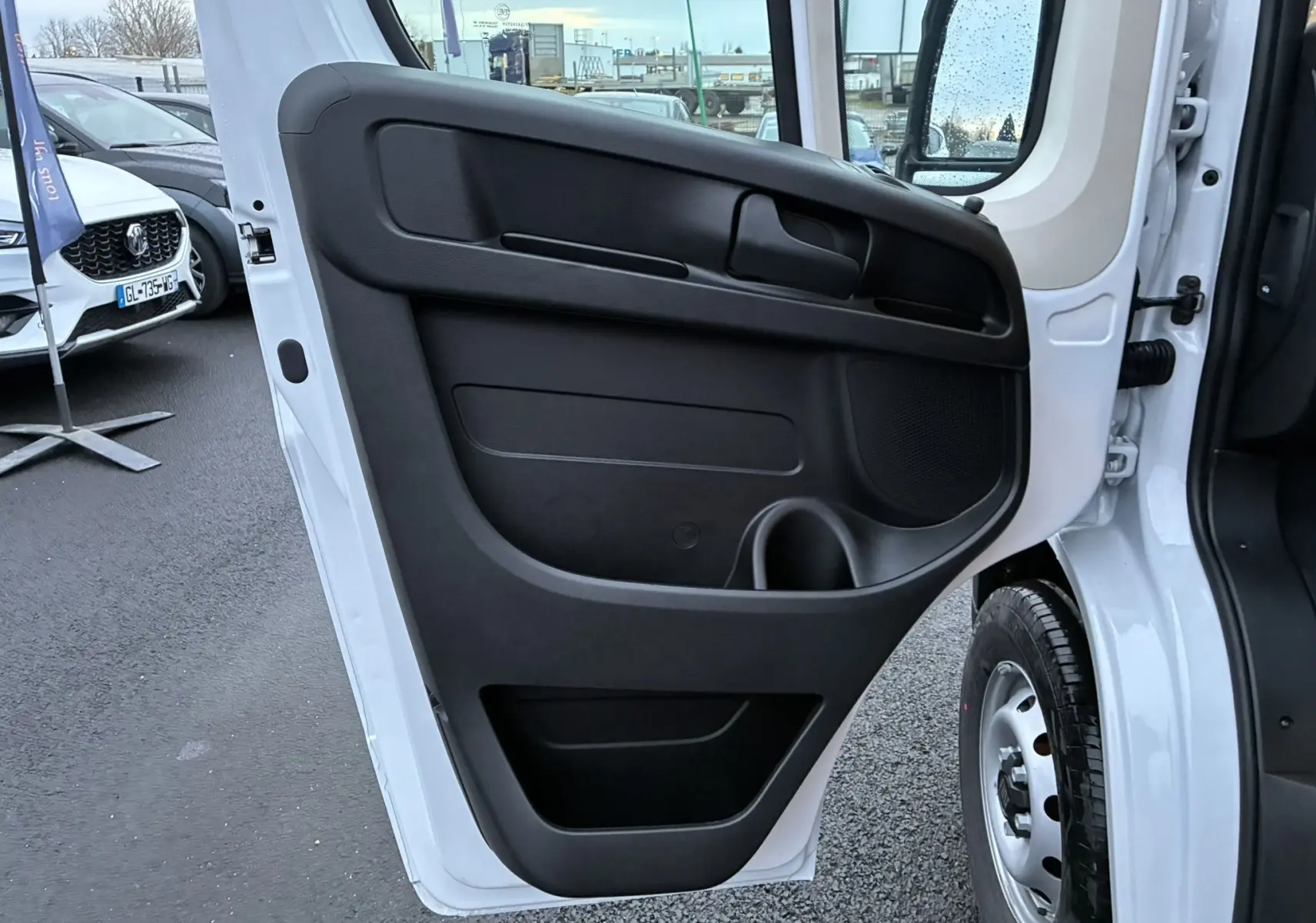 Vue rapprochée de la porte arrière droite ouverte du FIAT Ducato Fourgon blanc 2025, montrant le panneau intérieur noir.