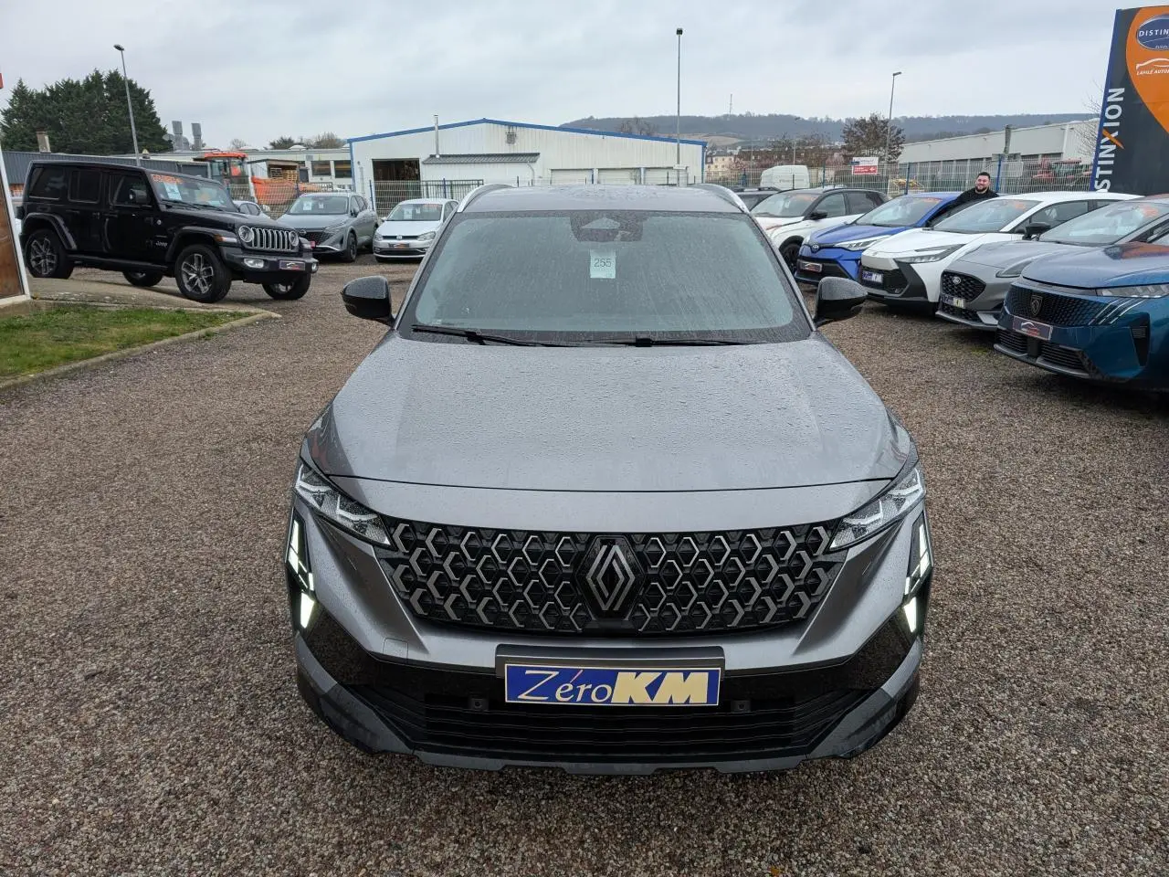Vue avant d’un Renault Austral gris avec calandre à motifs hexagonaux et feux LED en forme de crocs.