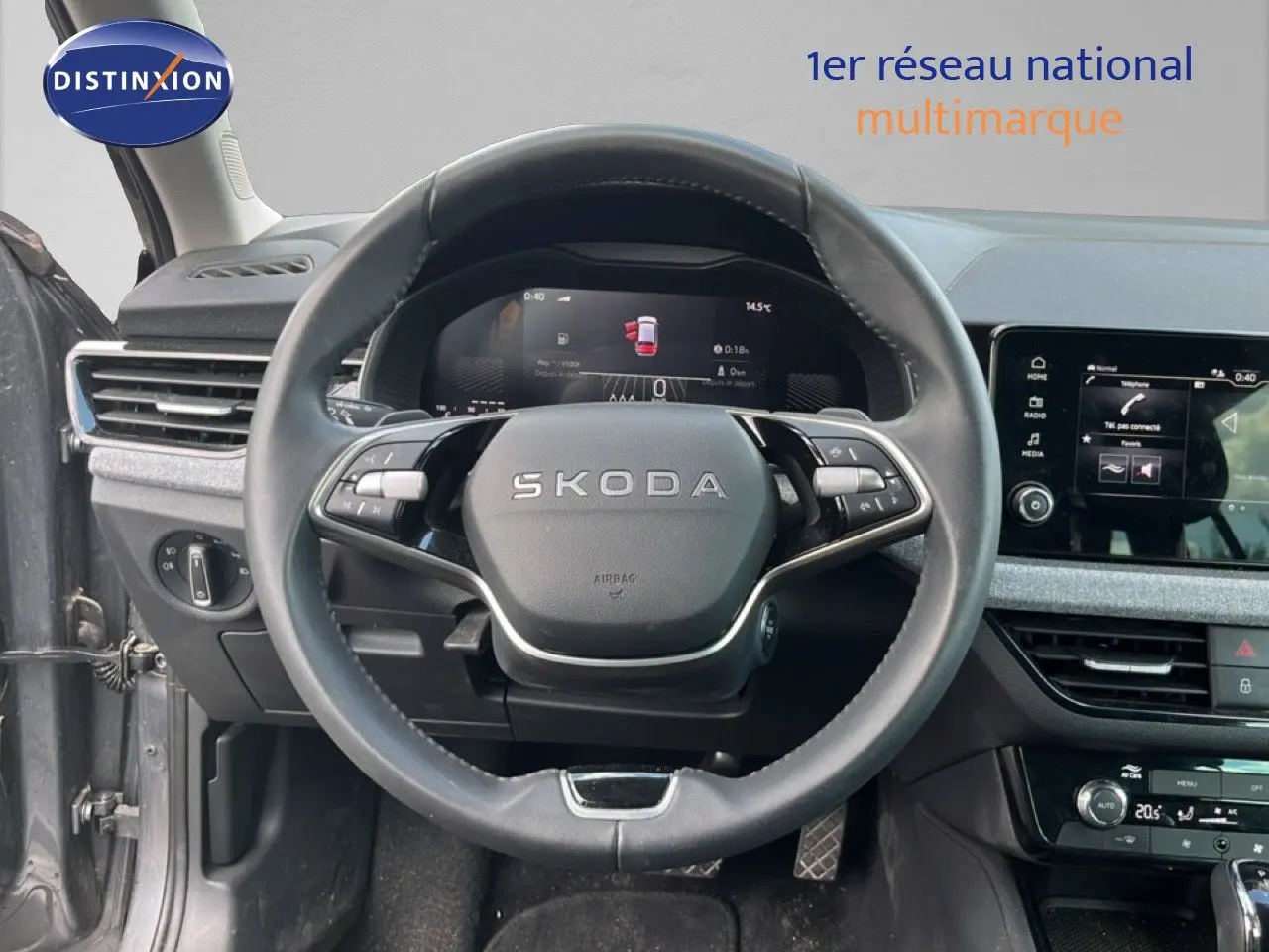 Vue intérieure centrée sur le volant cuir noir et le tableau de bord digital de la Skoda Scala gris métallique 2025.