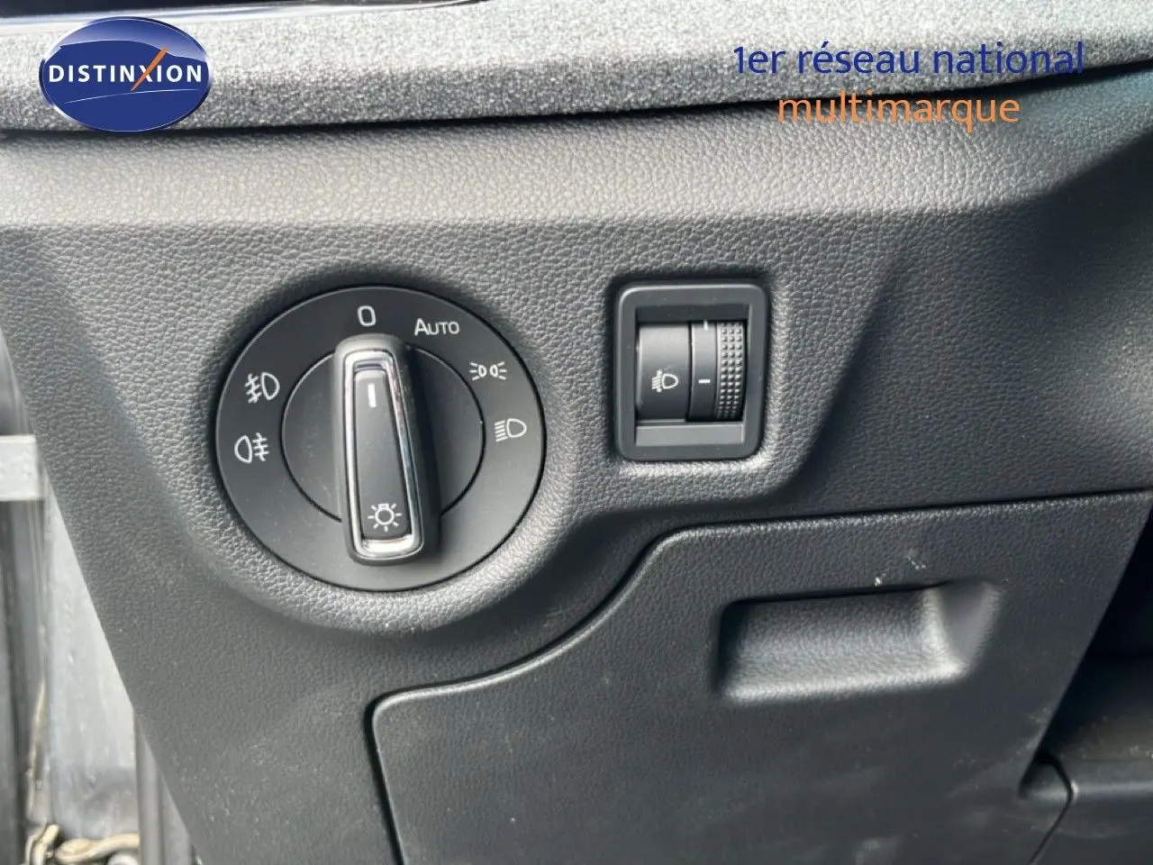 Gros plan sur le panneau de commande des phares intérieur d'une Skoda Scala gris magnétique, avec molette et réglage d'intensité.