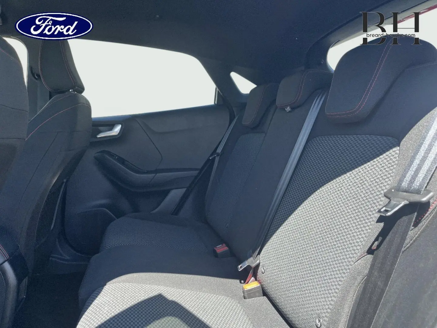 Vue intérieure côté droit des sièges arrière en tissu noir avec surpiqûres rouges du Ford Puma 2024 gris Solar métallisé.