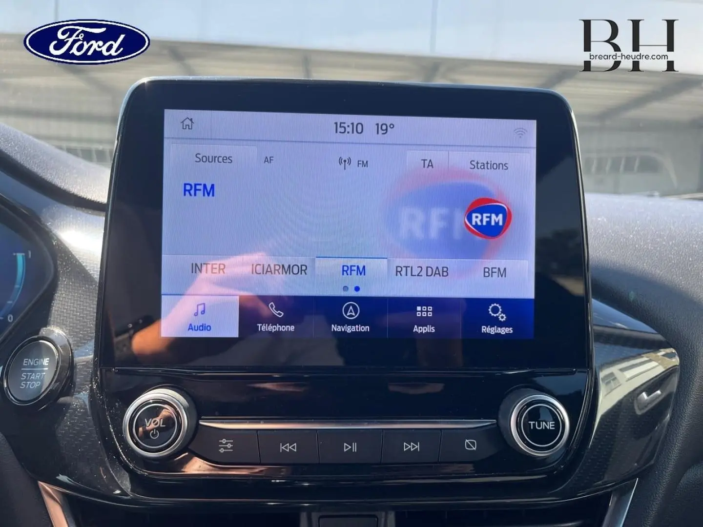 Écran tactile central du Ford Puma 2024 en gros plan, affichant les options radio avec finition noire brillante.