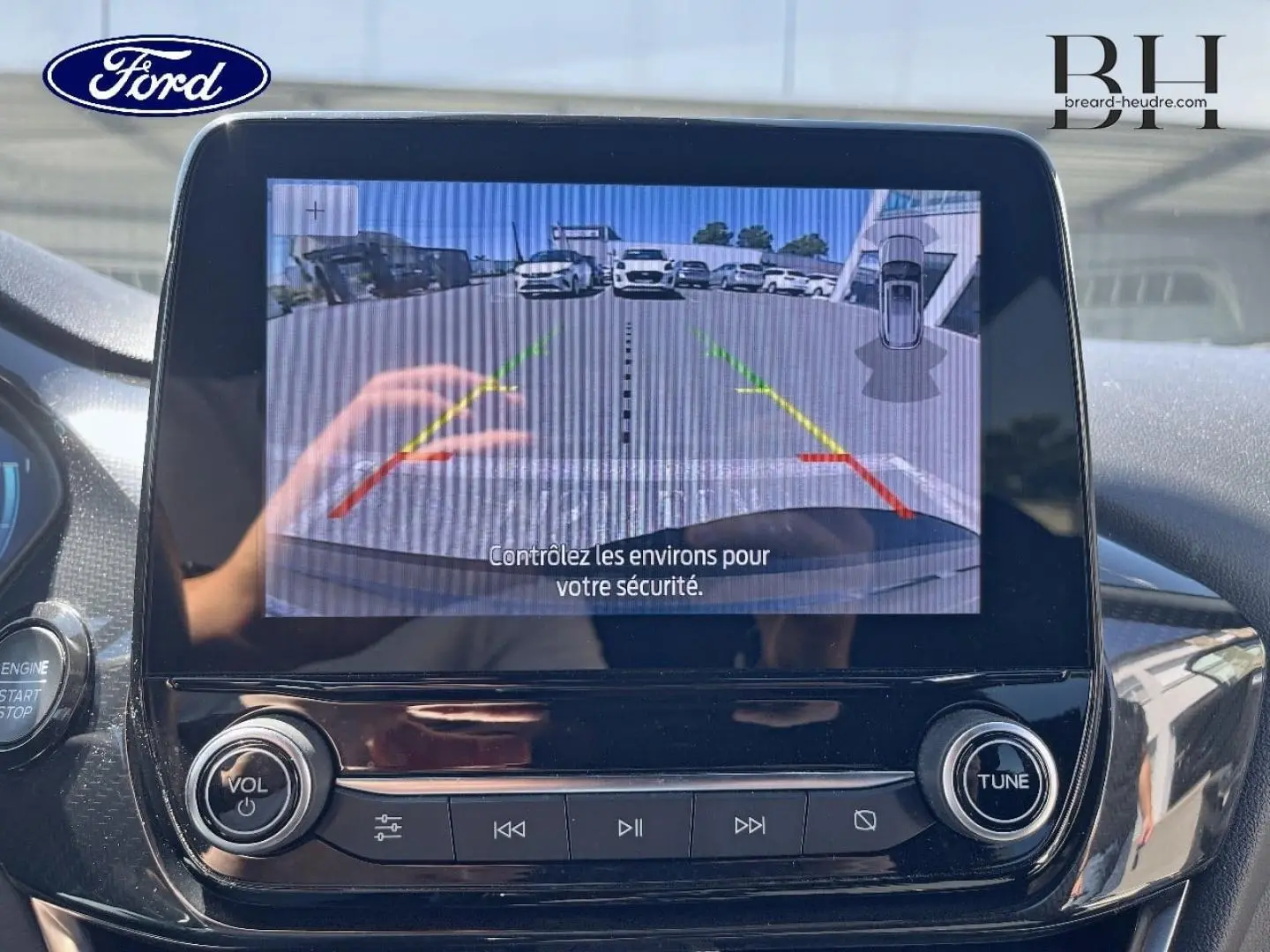 Écran central de la Ford Puma 2024 montrant la caméra de recul avec lignes de guidage colorées, intérieur noir brillant.