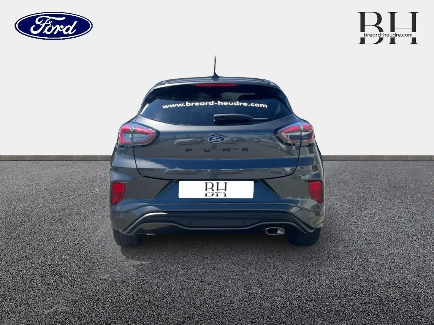 Vue arrière d'un Ford Puma 2024 gris Solar métallisé avec vitres arrière surteintées et échappement visible côté droit.