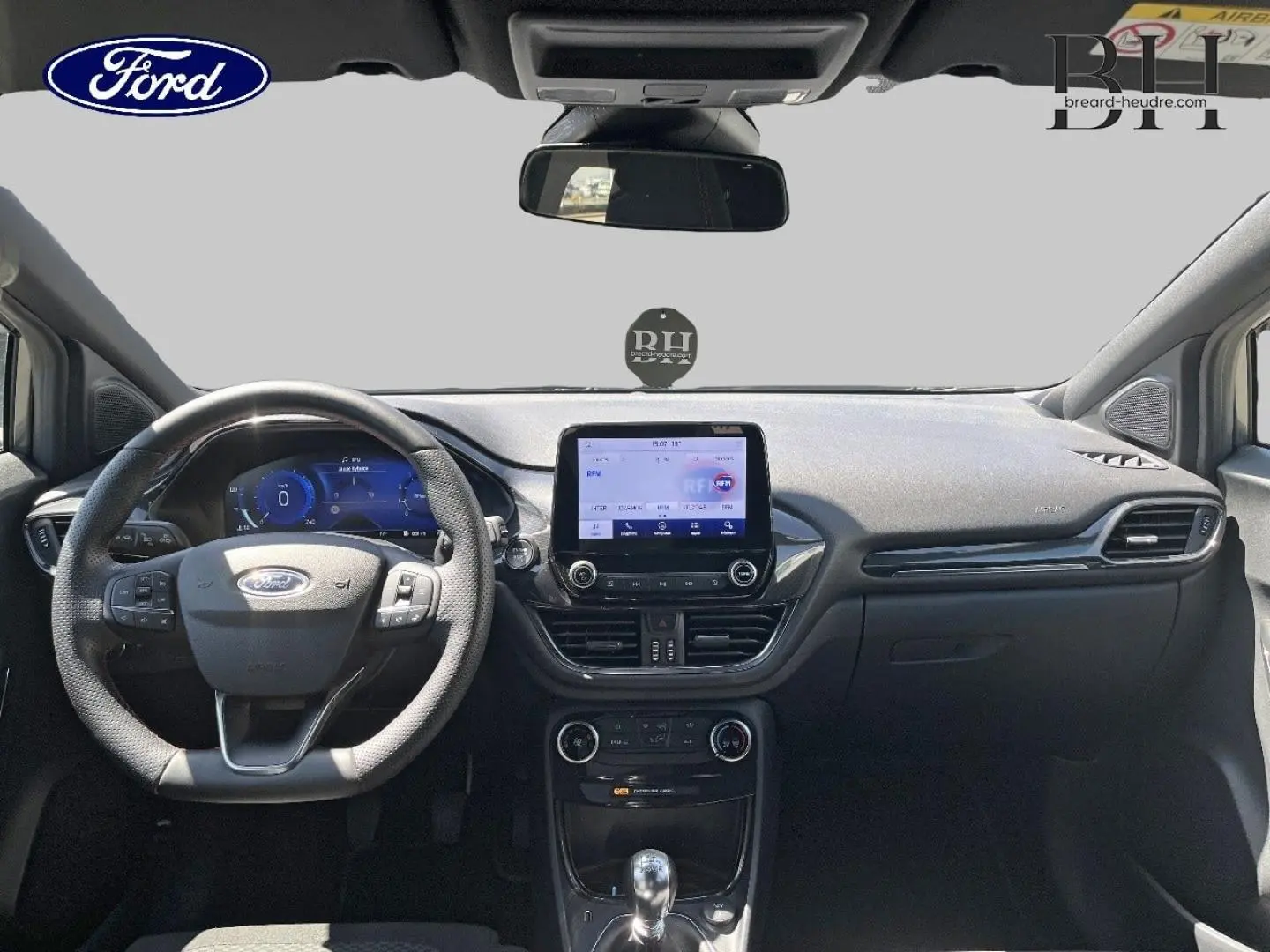 Vue intérieure frontale du tableau de bord et volant du Ford Puma 2024, avec écran tactile et finitions noires.