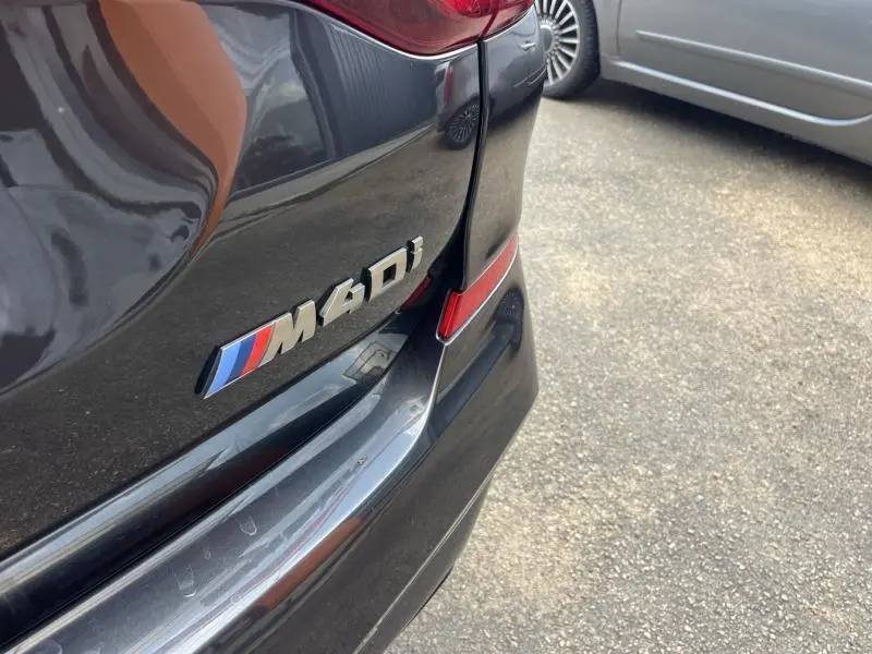 Gros plan sur l'arrière droit d'une BMW X3 M40iA Sophistograu métallisé avec logo M40i visible.