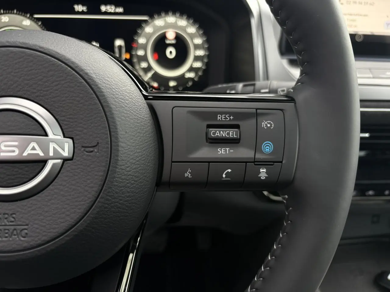 Gros plan sur le volant cuir du Nissan Qashqai 2025, côté droit avec commandes de régulateur et assistance conduite.