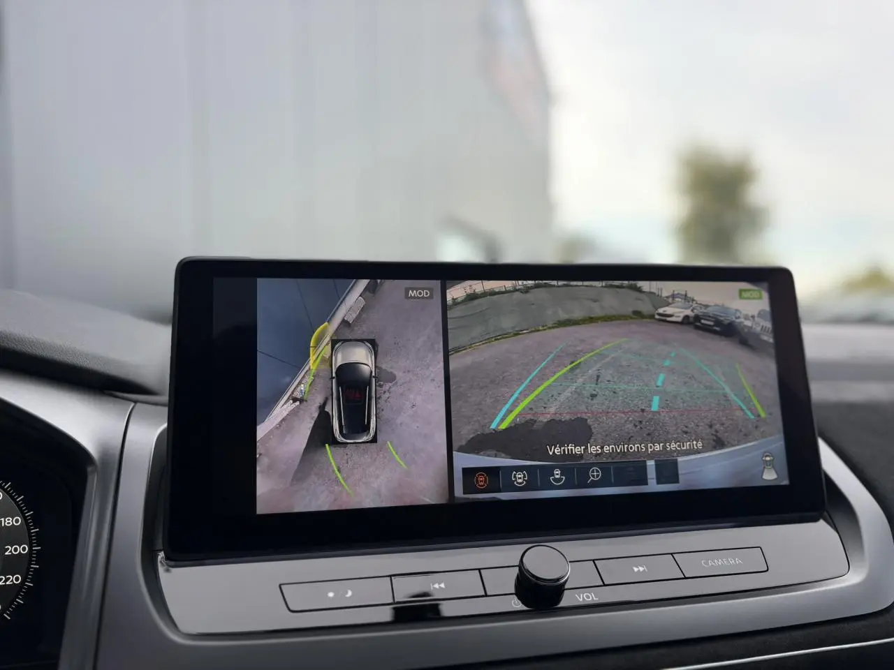 Écran tactile du Nissan Qashqai 2025 affichant la caméra 360° et vue arrière en stationnement, intérieur gris.
