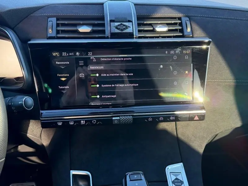 Vue rapprochée de l'écran tactile central et de la console du DS7 E-TENSE 225ch gris Titane avec commandes modernes et finition noire.