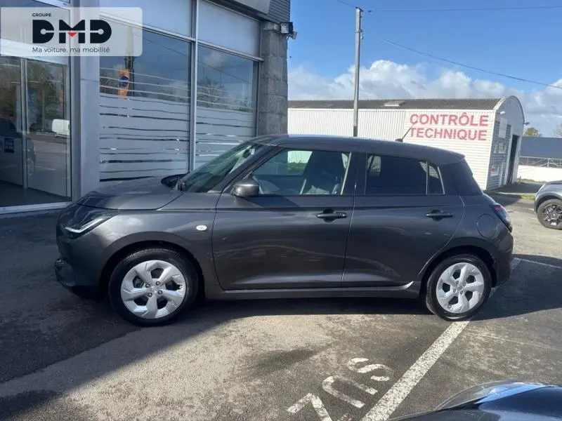 Profil droit de la Suzuki Swift 1.2 Hybrid 83ch Privilège 2024 en Mineral Gray Metal, avec jantes alu et poignées ton carrosserie.