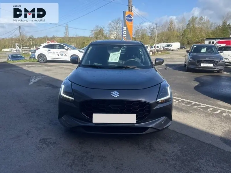 Vue avant d'une Suzuki Swift 1.2 Hybrid 83ch Privilège gris Mineral Gray Metal avec calandre noire et phares LED allumés.