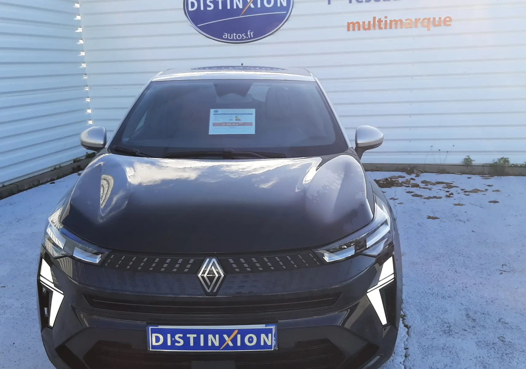 Vue frontale du Renault Captur 1.3 TCE 140 MHEV TECHNO 2024 en noir métal avec toit gris, feux LED allumés.