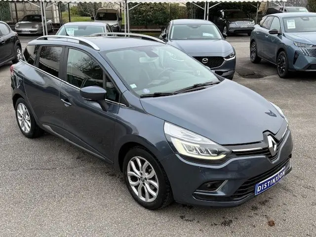 Renault Clio IV Estate TCE 90 Energy Intens gris titanium vue 3/4 avant avec jantes alliage et feux LED allumés.