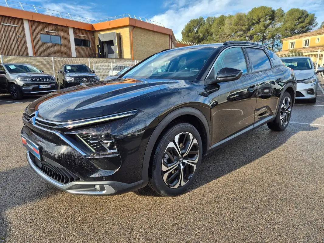 Vue 3/4 avant droite d'une Citroën C5 X noire 2024 avec jantes alliage 19 pouces et phares LED distinctifs.