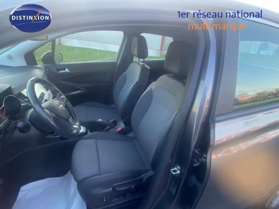Vue intérieure côté conducteur de l’Opel Crossland gris foncé, montrant les sièges avant et le volant multifonctions en cuir.