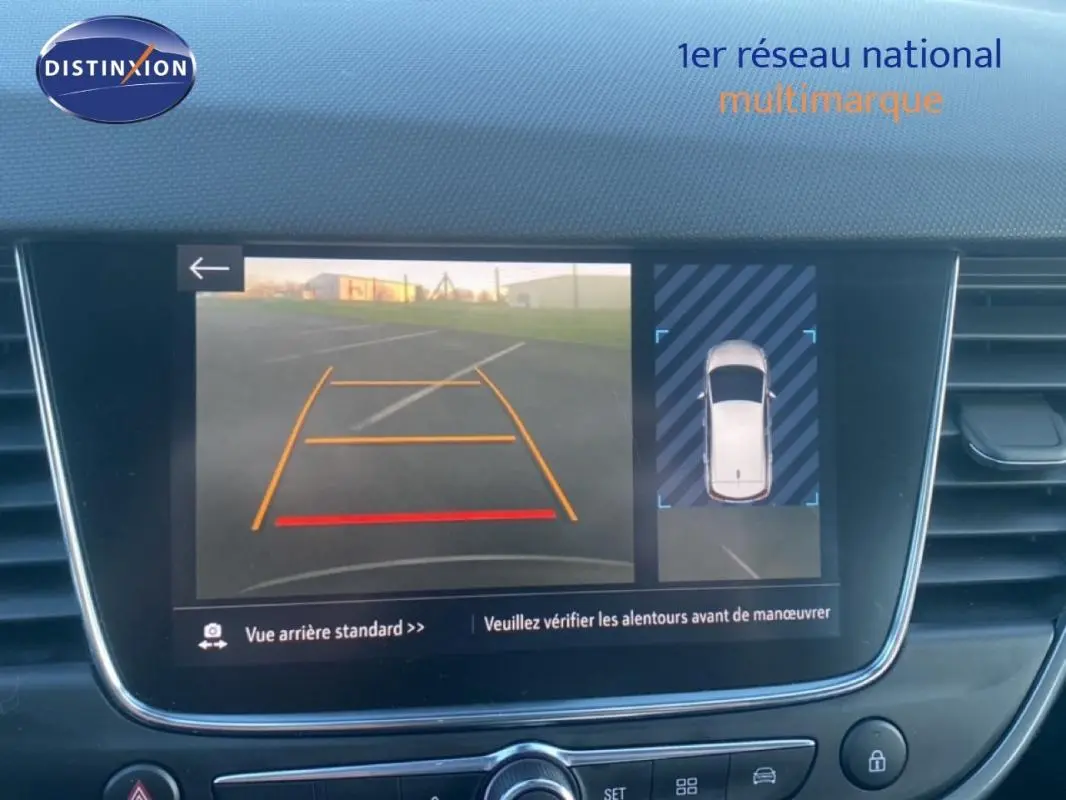 Écran intérieur affichant la caméra de recul et vue 360° d’une Opel Crossland gris foncé, tableau de bord moderne.