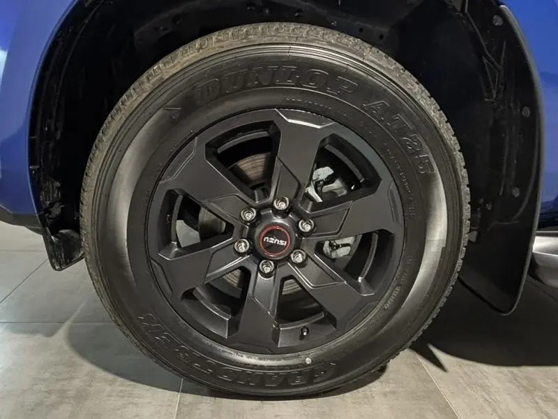 Gros plan sur la jante noire alu et pneu Dunlop du côté avant droit de l'Isuzu D-MAX Biarritz Blue Metallic 2025.