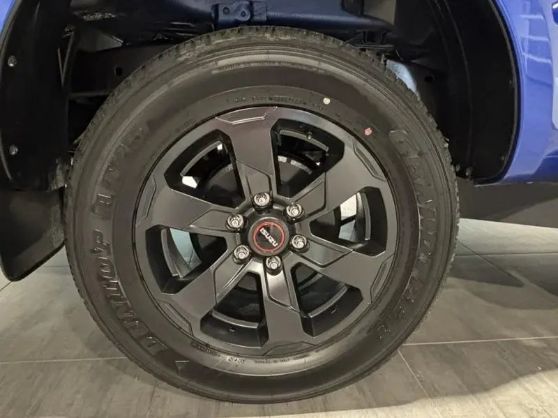 Gros plan sur la jante noire alu du côté gauche de l'Isuzu D-MAX 2025 Biarritz Blue Metallic.