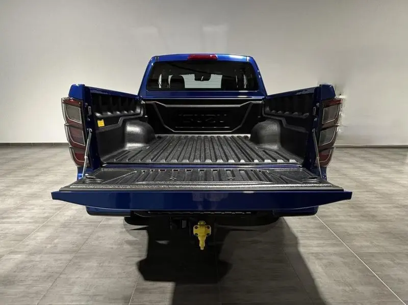 Vue arrière d'un pick-up Isuzu D-MAX 2025 Biarritz Blue Metallic avec benne ouverte et hayon abaissé.