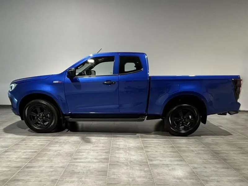 Profil côté gauche d'un pick-up Isuzu D-MAX 2025 en Biarritz Blue Metallic avec jantes noires et cabine allongée.