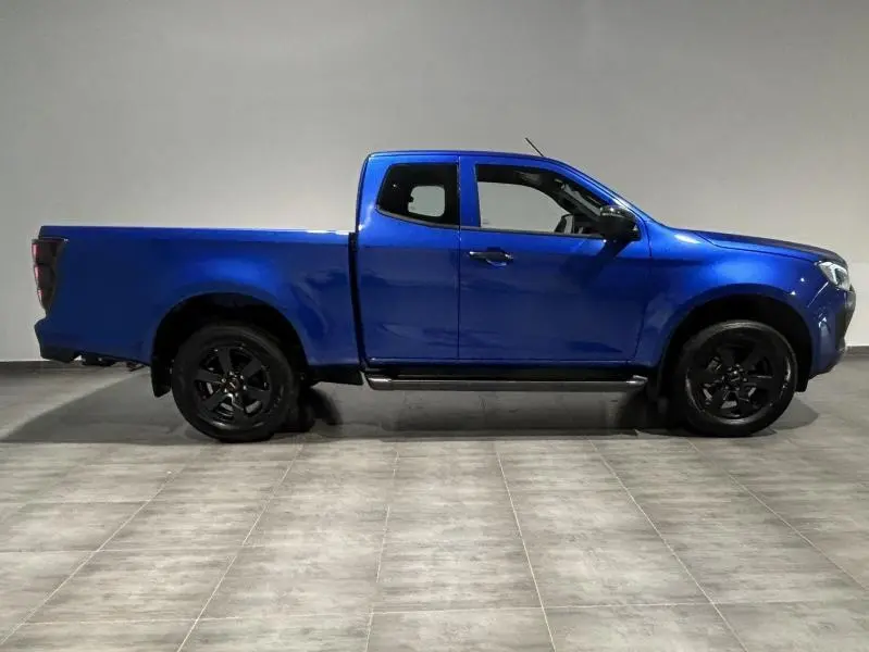 Profil côté gauche du pick-up Isuzu D-MAX 2025 en bleu Biarritz métallisé avec jantes noires et cabine double.