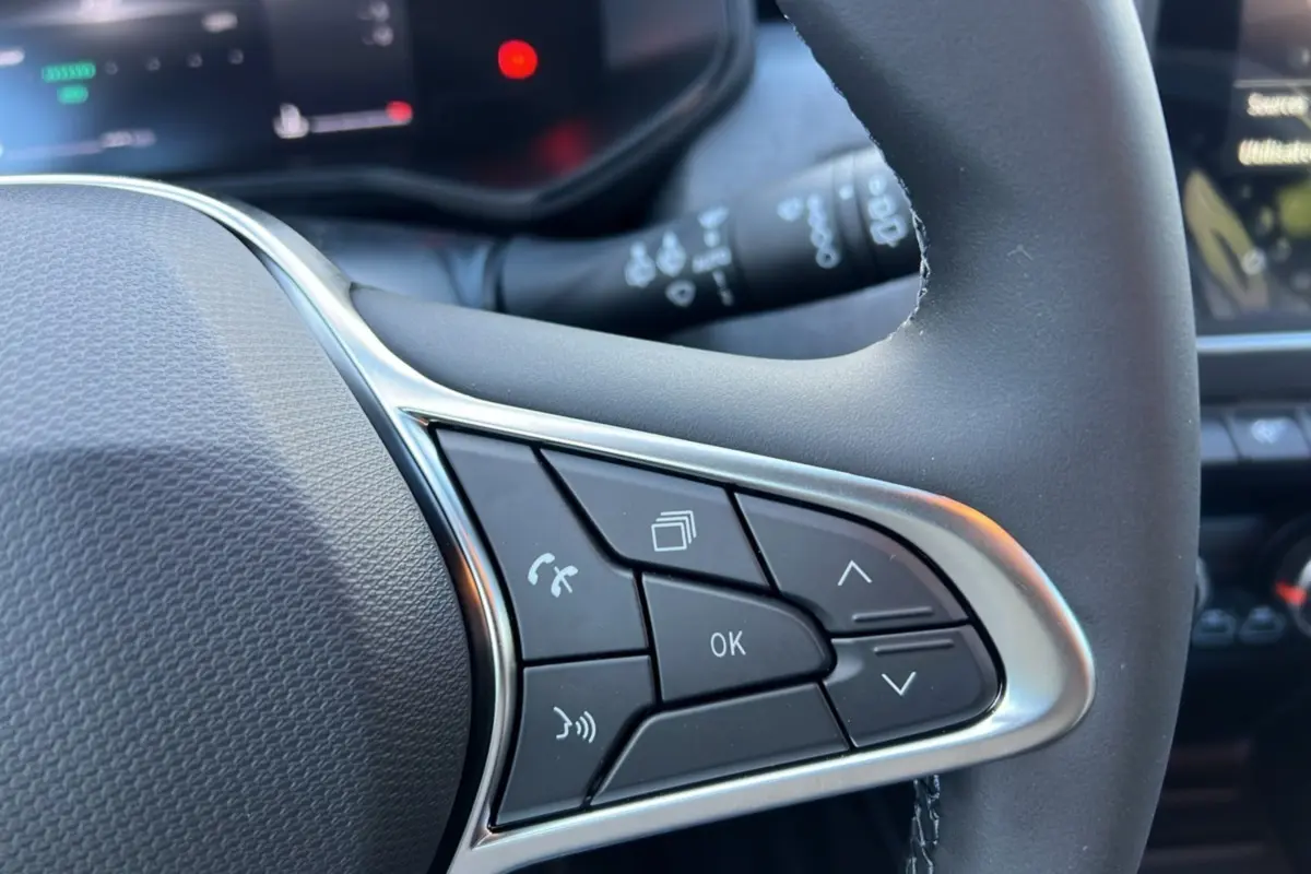 Gros plan sur les commandes multifonctions à gauche du volant de la Renault Clio DCI 100 Evolution gris schiste 2025.