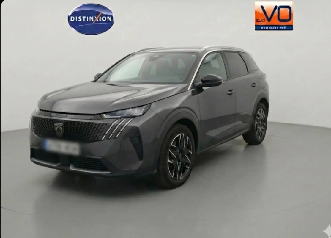 Peugeot 5008 Hybrid gris en 3/4 avant droit, avec calandre noire distinctive et jantes alliage 19 pouces.