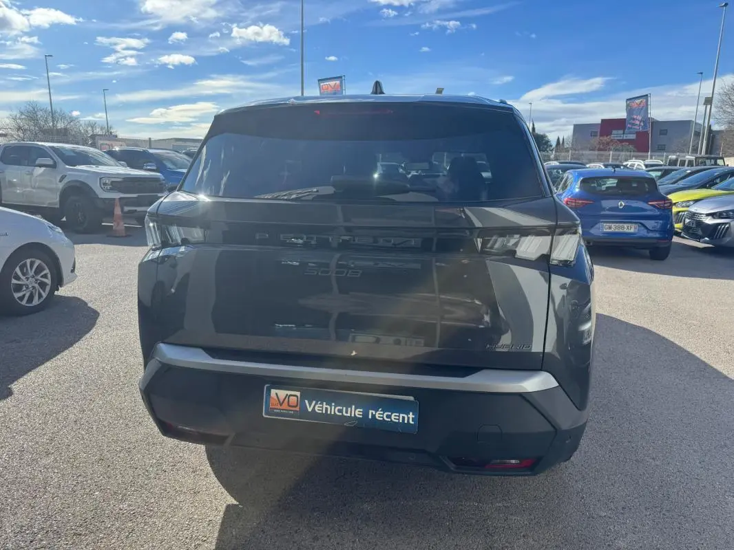 Vue arrière d’un Peugeot 5008 Hybrid gris 2025 avec feux arrière LED et jantes alliage 19 pouces visibles en extérieur.