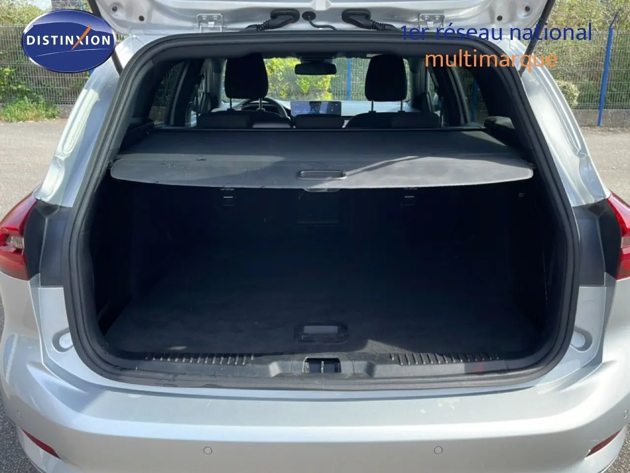 Vue arrière du coffre ouvert d'une Ford Focus SW 2023 gris lunaire métal, montrant l'espace de chargement vide.