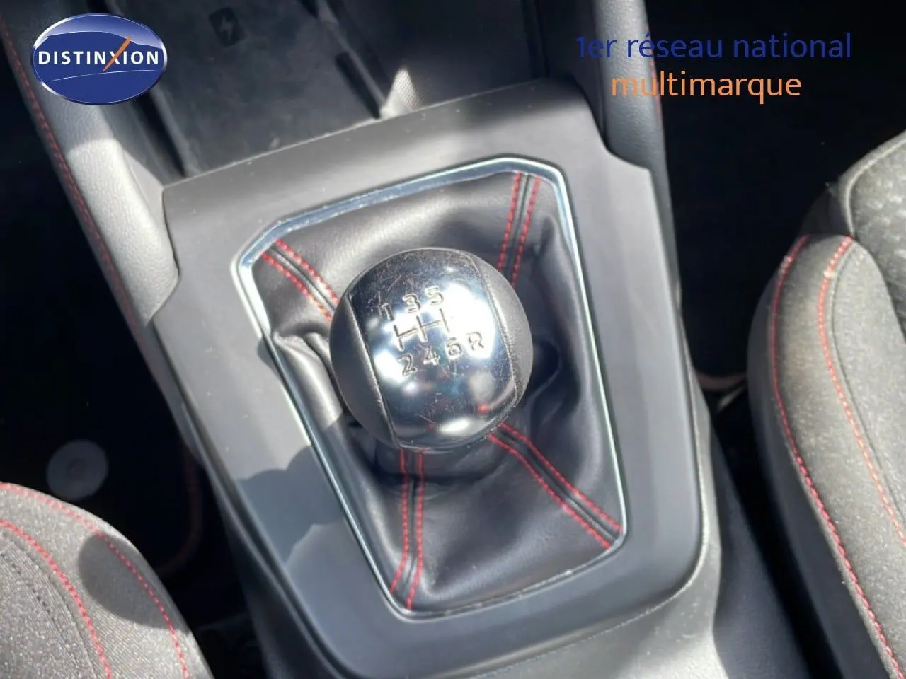 Gros plan sur le levier de vitesses manuel avec soufflet noir et surpiqûres rouges dans une Ford Focus SW gris lunaire 2023.
